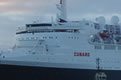 Photograph of a port side view of the QE2 as she arrives into Southampton Docks